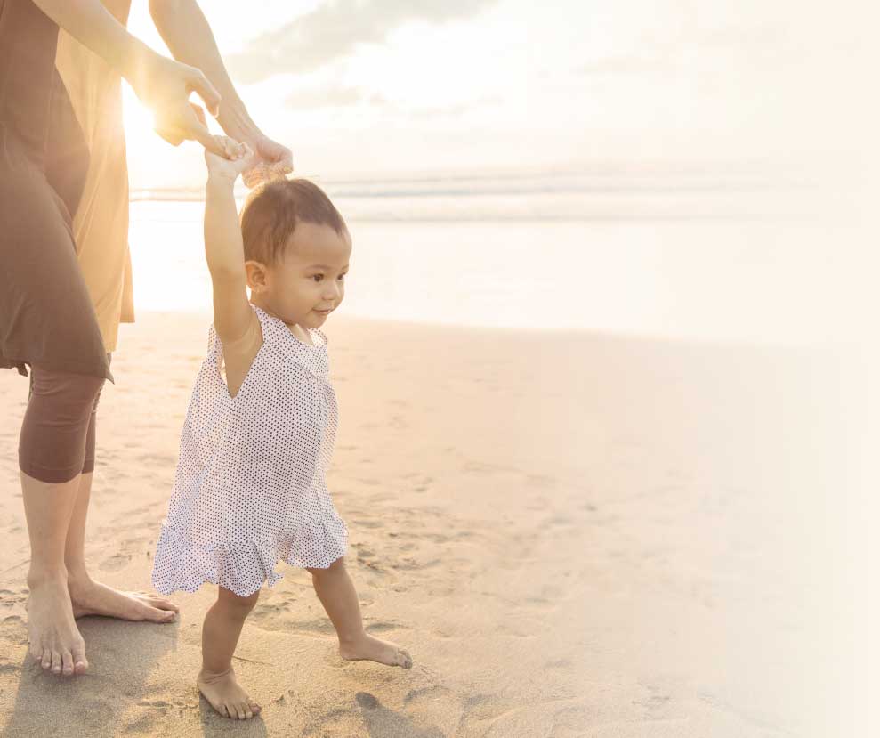 Mother walking child on sand