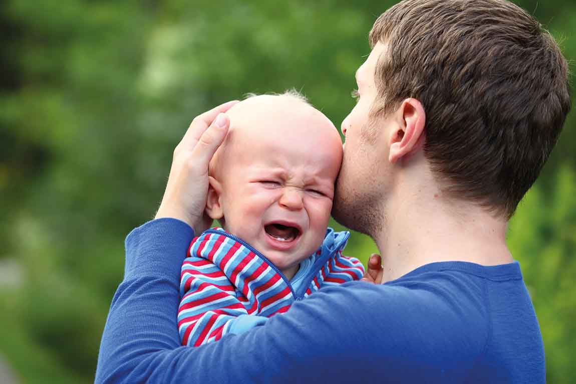 Man holding crying baby